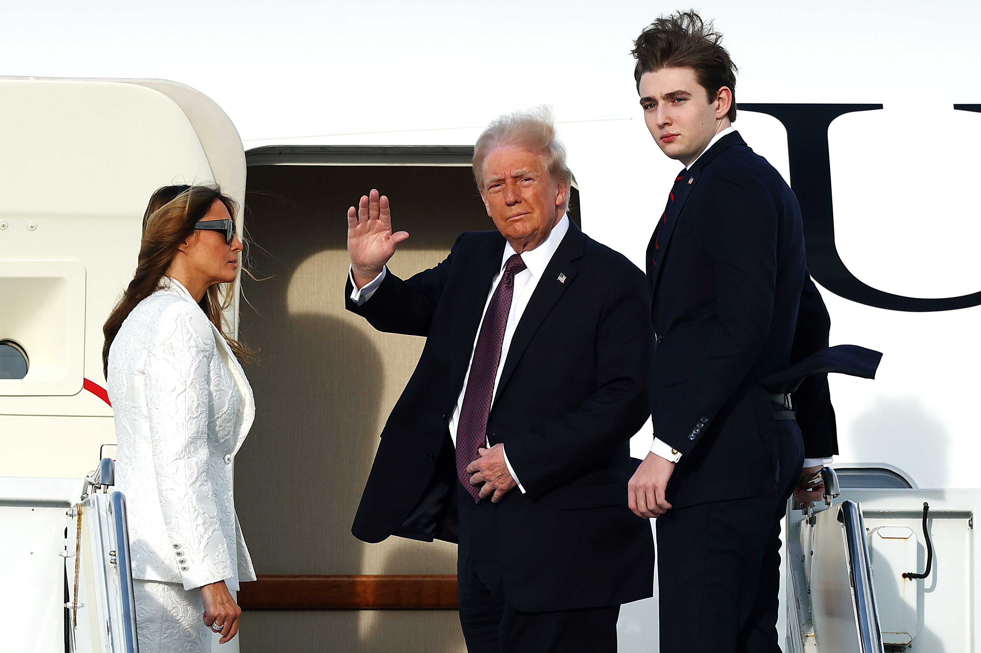 Three radical successful ceremonial covering basal adjacent an airplane's entrance. One idiosyncratic waves portion the others look towards the camera