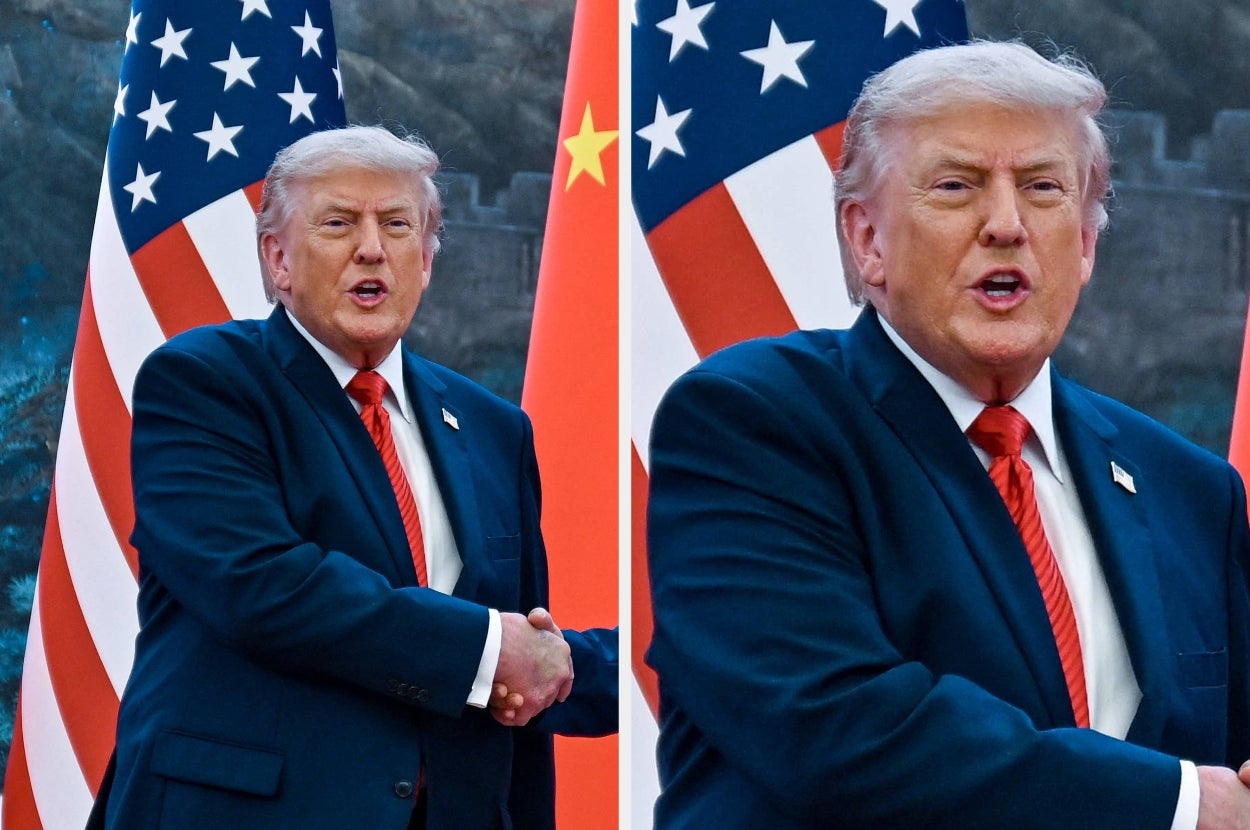 Man in suit and red tie stands in front of U.S. and Chinese flags, shaking hands, possibly at a diplomatic event