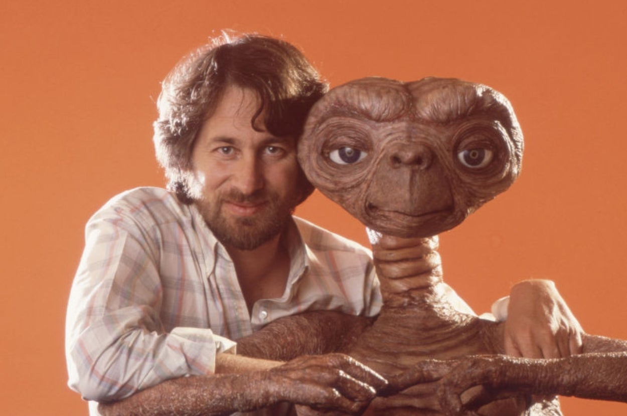 Steven Spielberg with his arms around E.T., posing