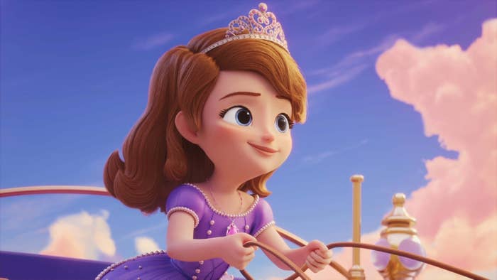 Animated princess character riding a carriage, smiling, wearing a tiara and a royal gown. Sky with clouds in the background