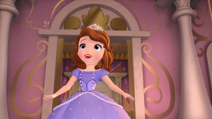 Animated princess character in a purple gown and tiara stands cheerfully in a castle with ornate decorations