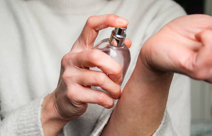 Person spraying perfume connected  wrist, close-up view