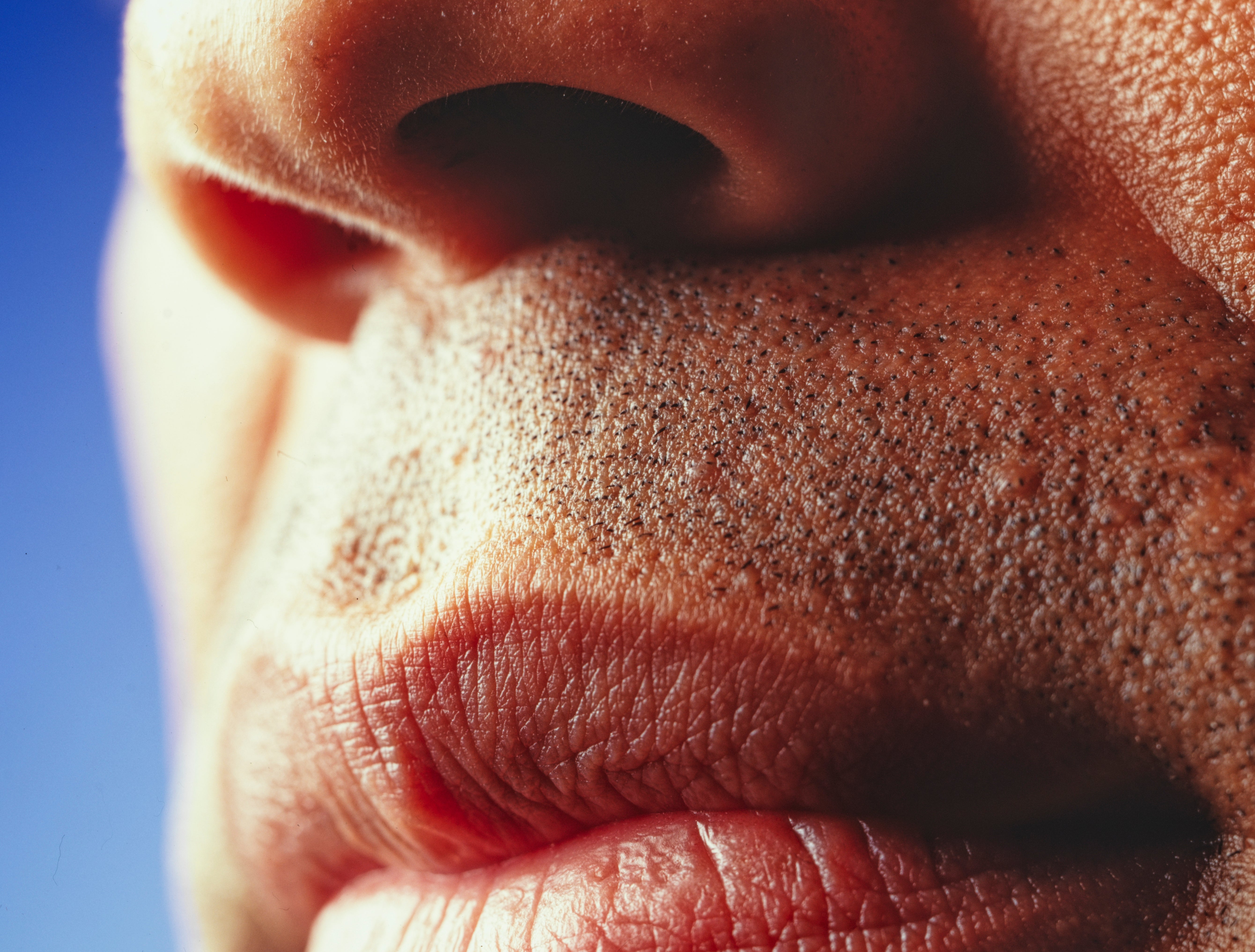 Close-up of a person's chemoreceptor and lips, showing tegument texture and stubble details