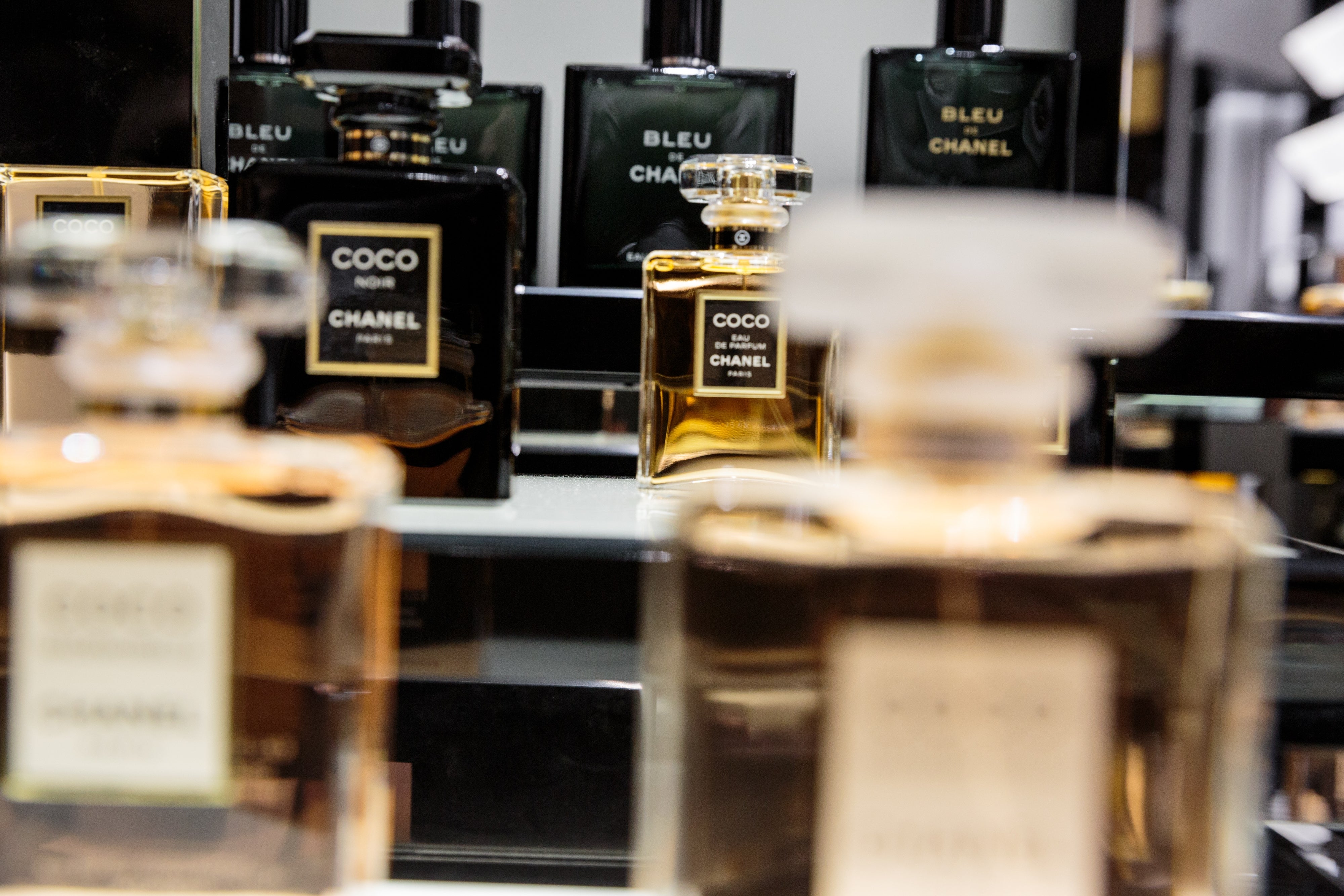 Various Chanel perfume bottles displayed connected a mirrored surface