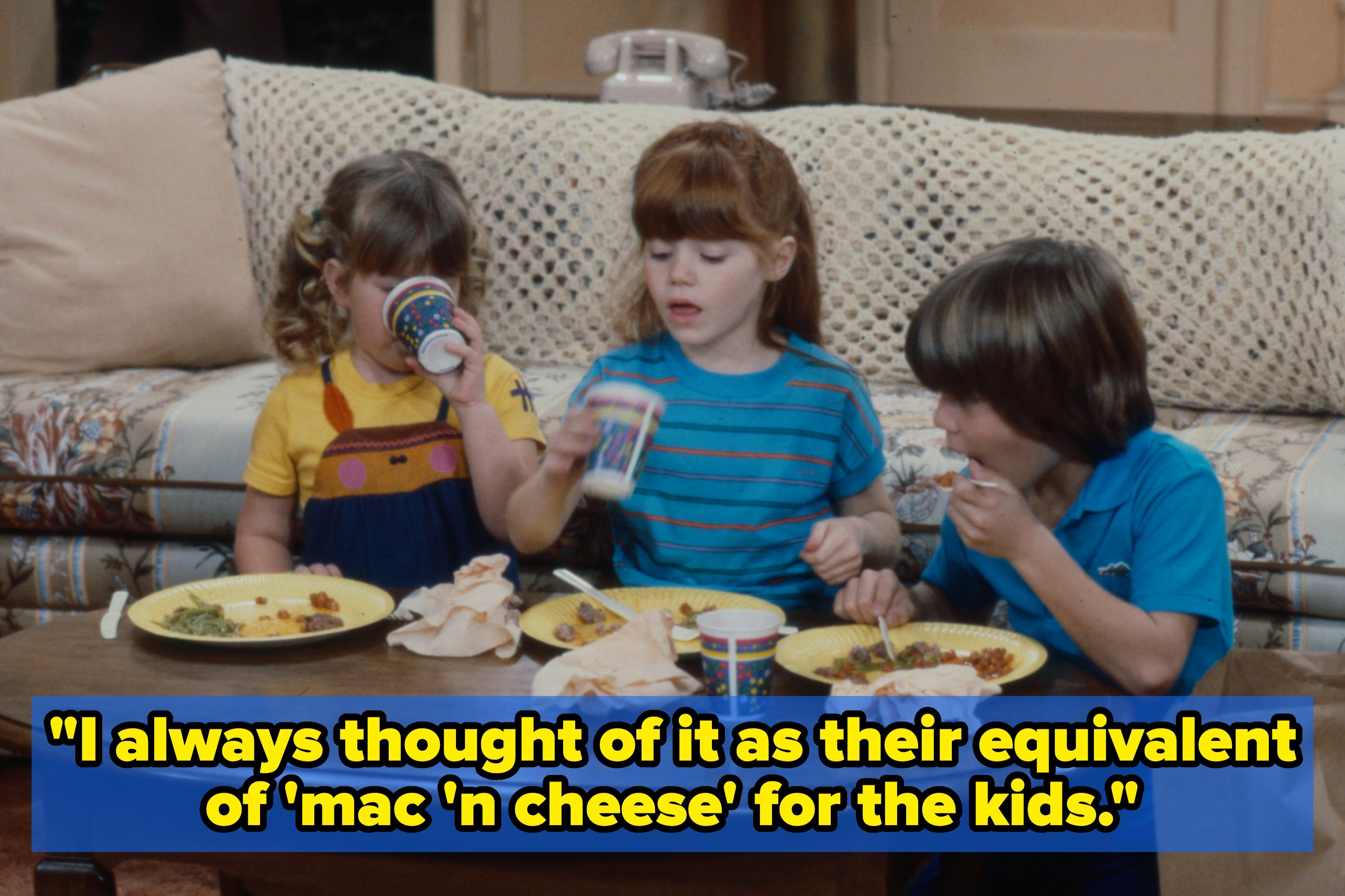 Children sitting at a cafeteria table; overlaid text reads, "I always thought of it as their equivalent of 'mac 'n cheese' for the kids."
