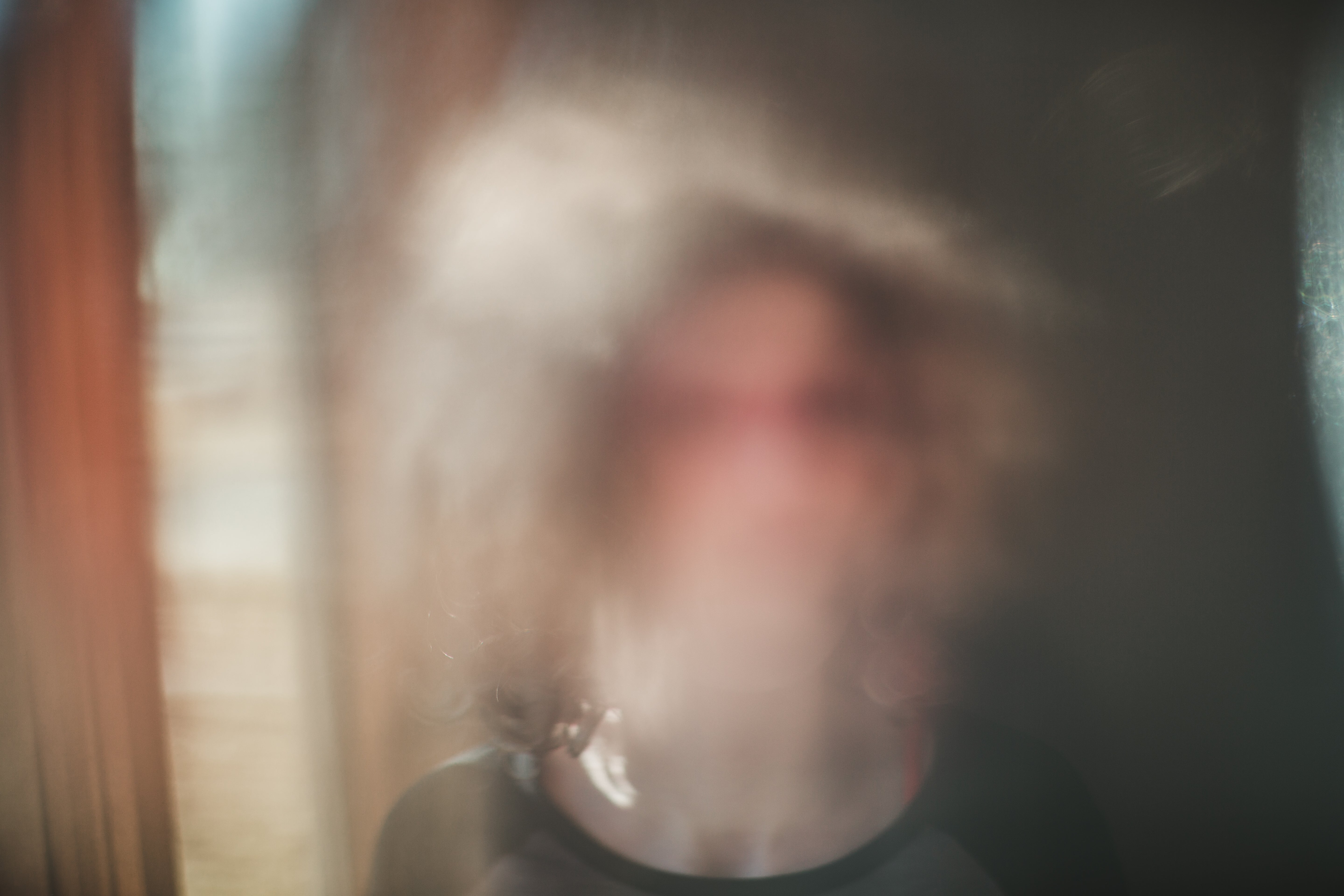 A blurry silhouette of a idiosyncratic is visible, creating an abstract, dreamlike effect