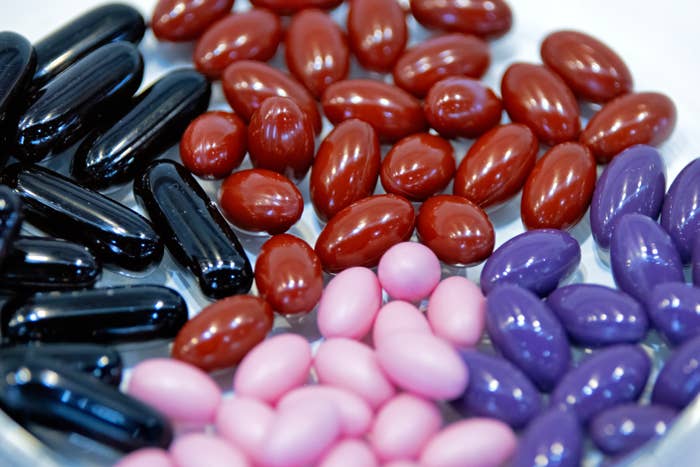 Assorted capsules and pills connected  a plate, featuring antithetic  shapes and sizes