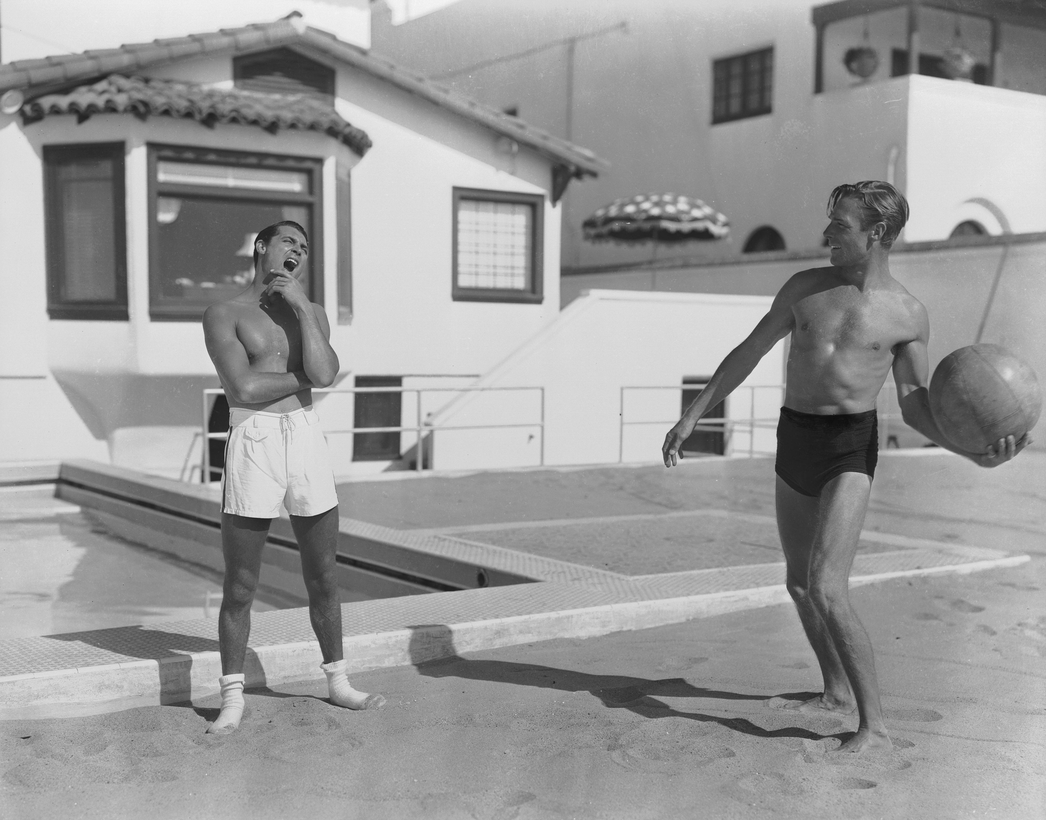 Randolph Scott and Cary Grant playing with a ball at their beach house