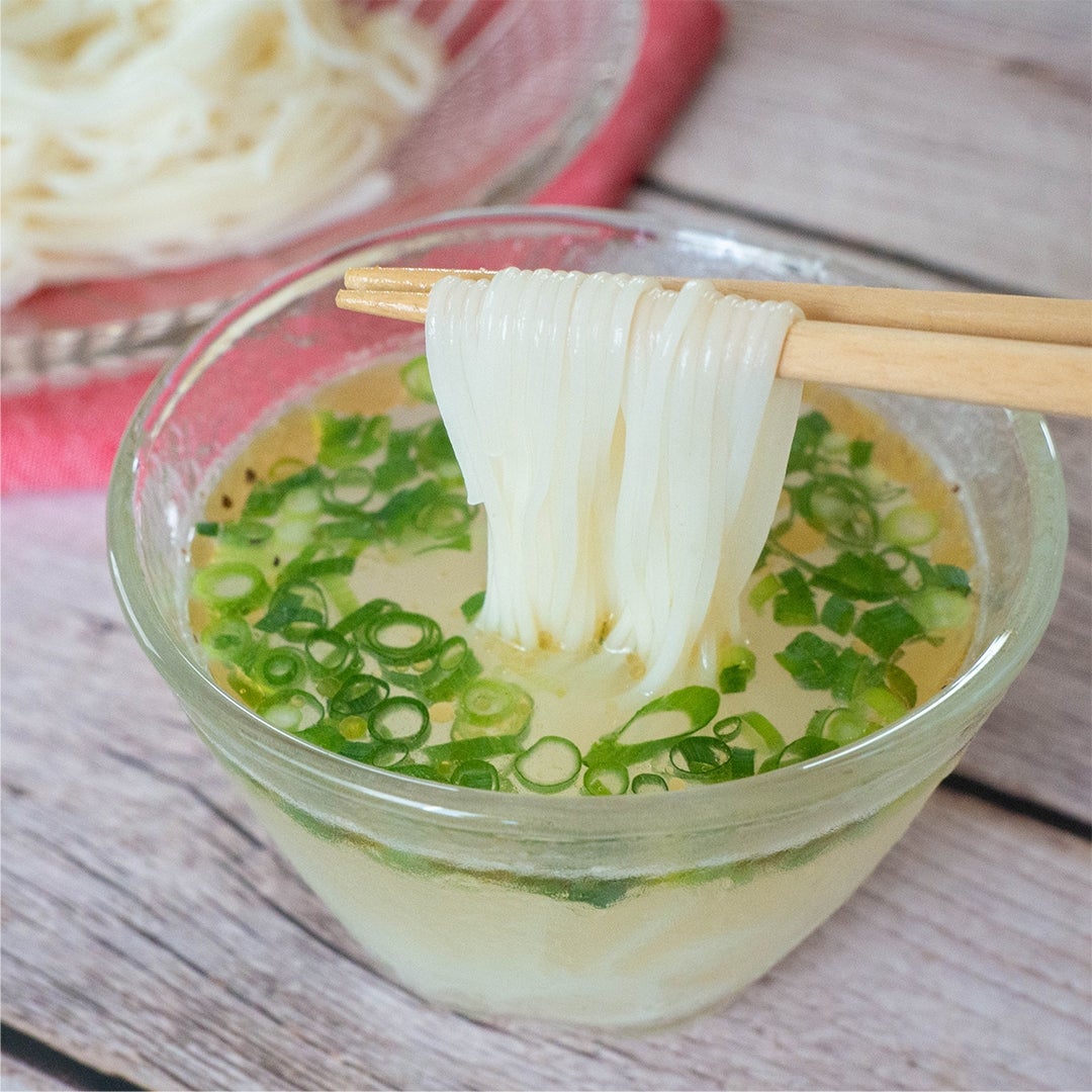 そうめんを箸で持ち上げている。