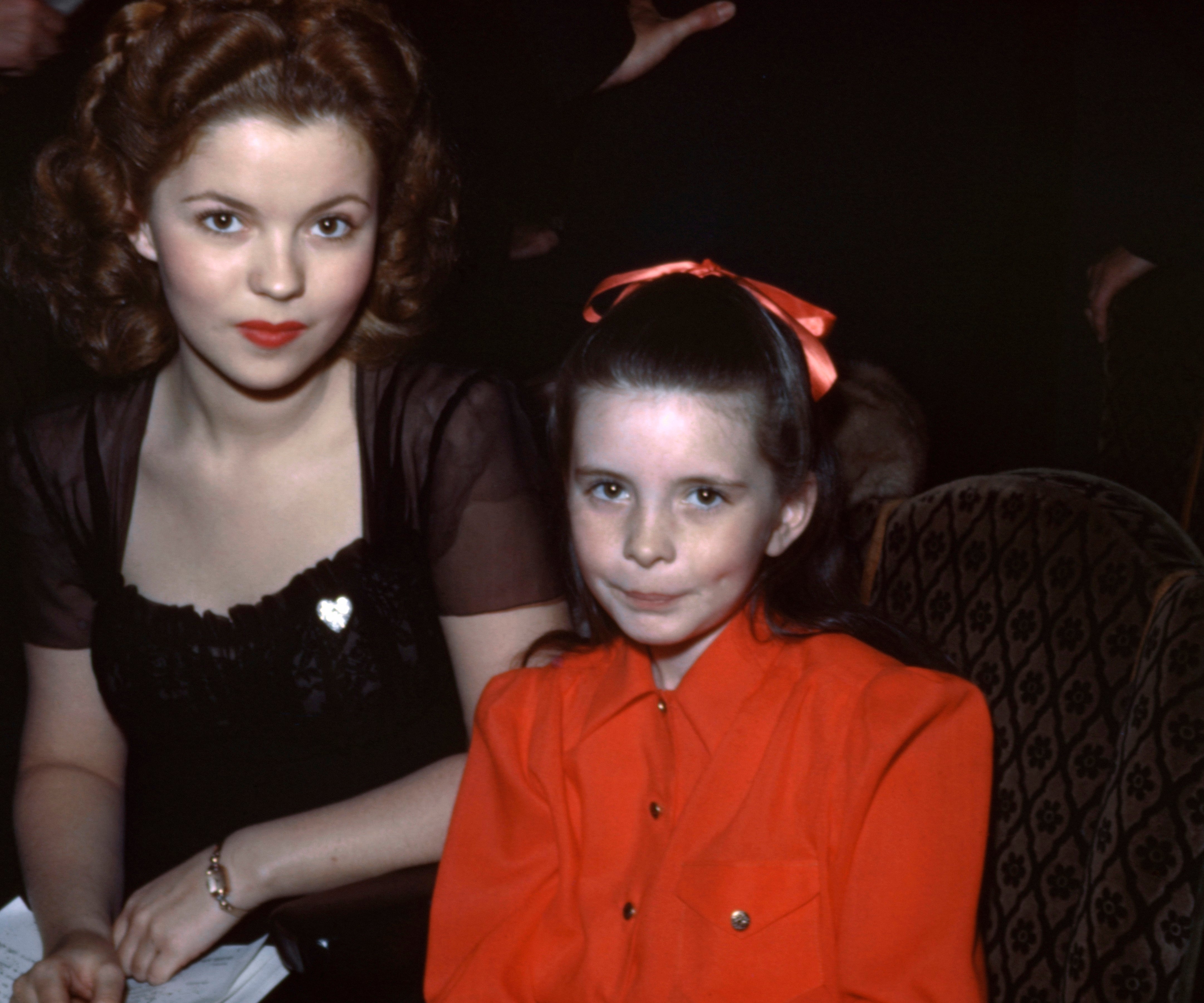 Shirley Temple and Margaret O'Brien seated, both looking at the camera