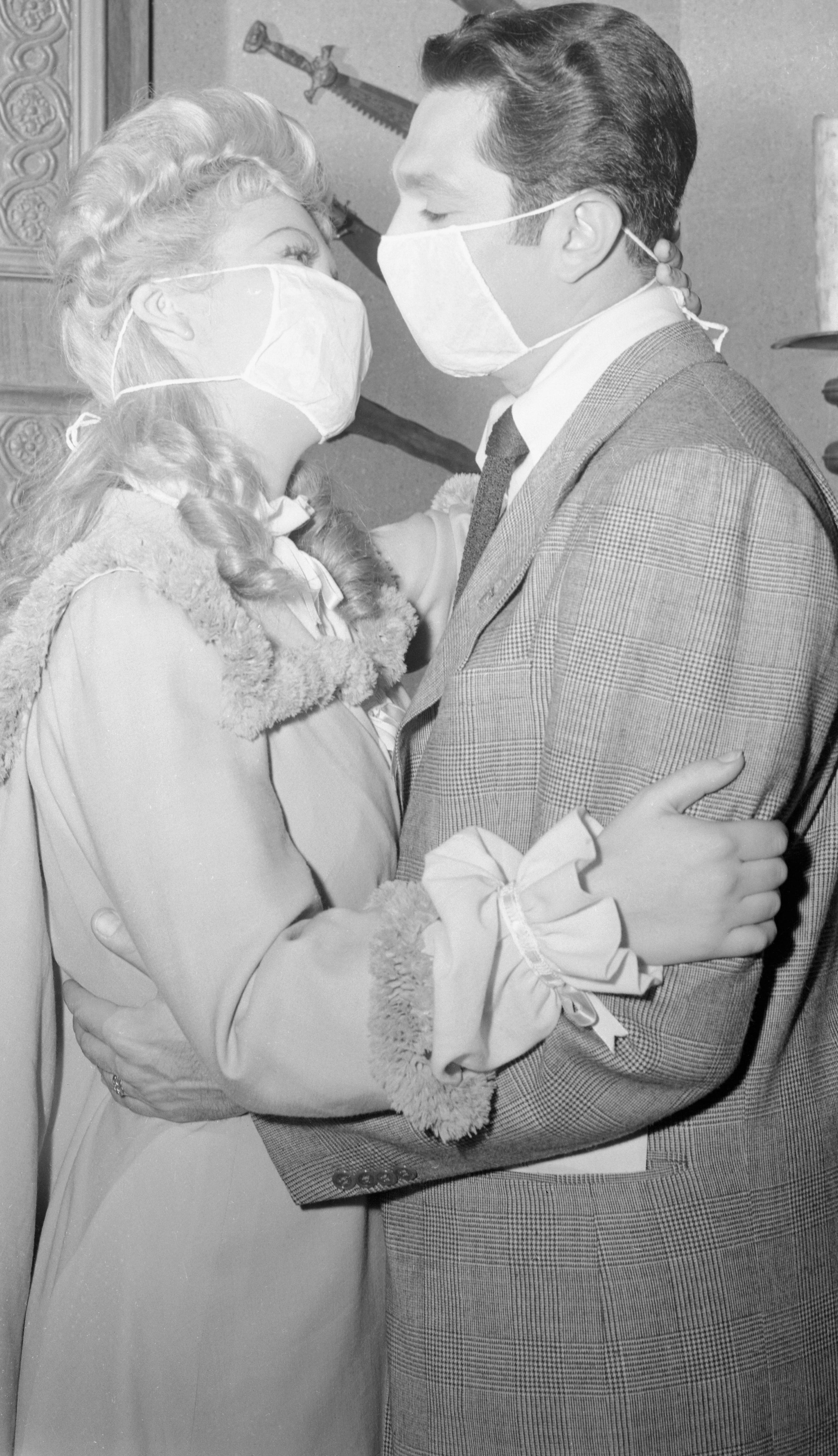 Andrea King and Bob Alda rehearing a kissing scene with masks on their faces