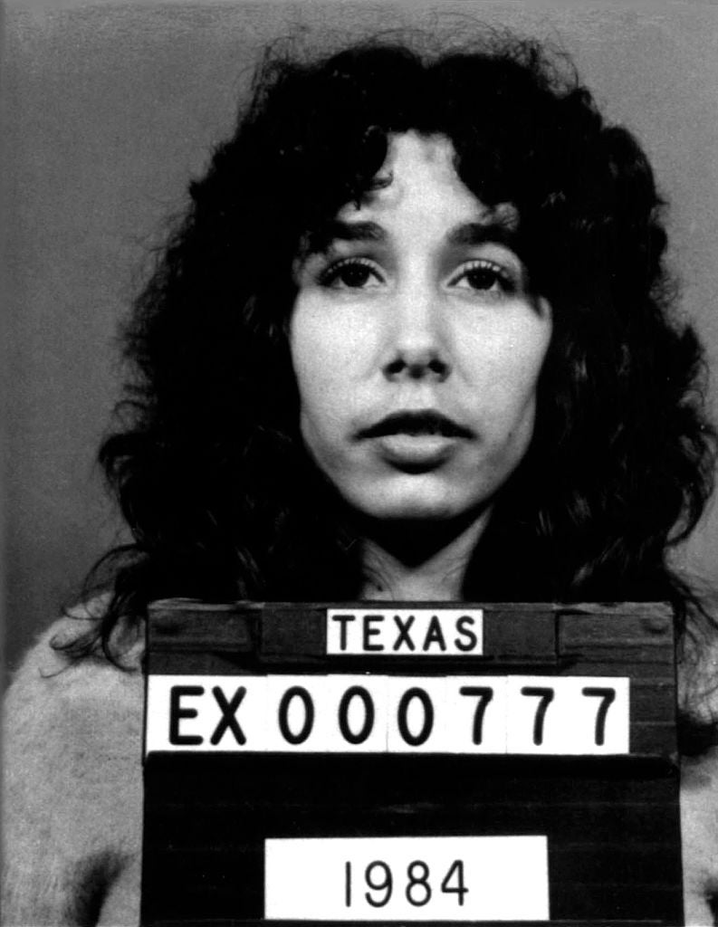 Person with curly hair holds a Texas mugshot sign with ID number EX000777 from 1984