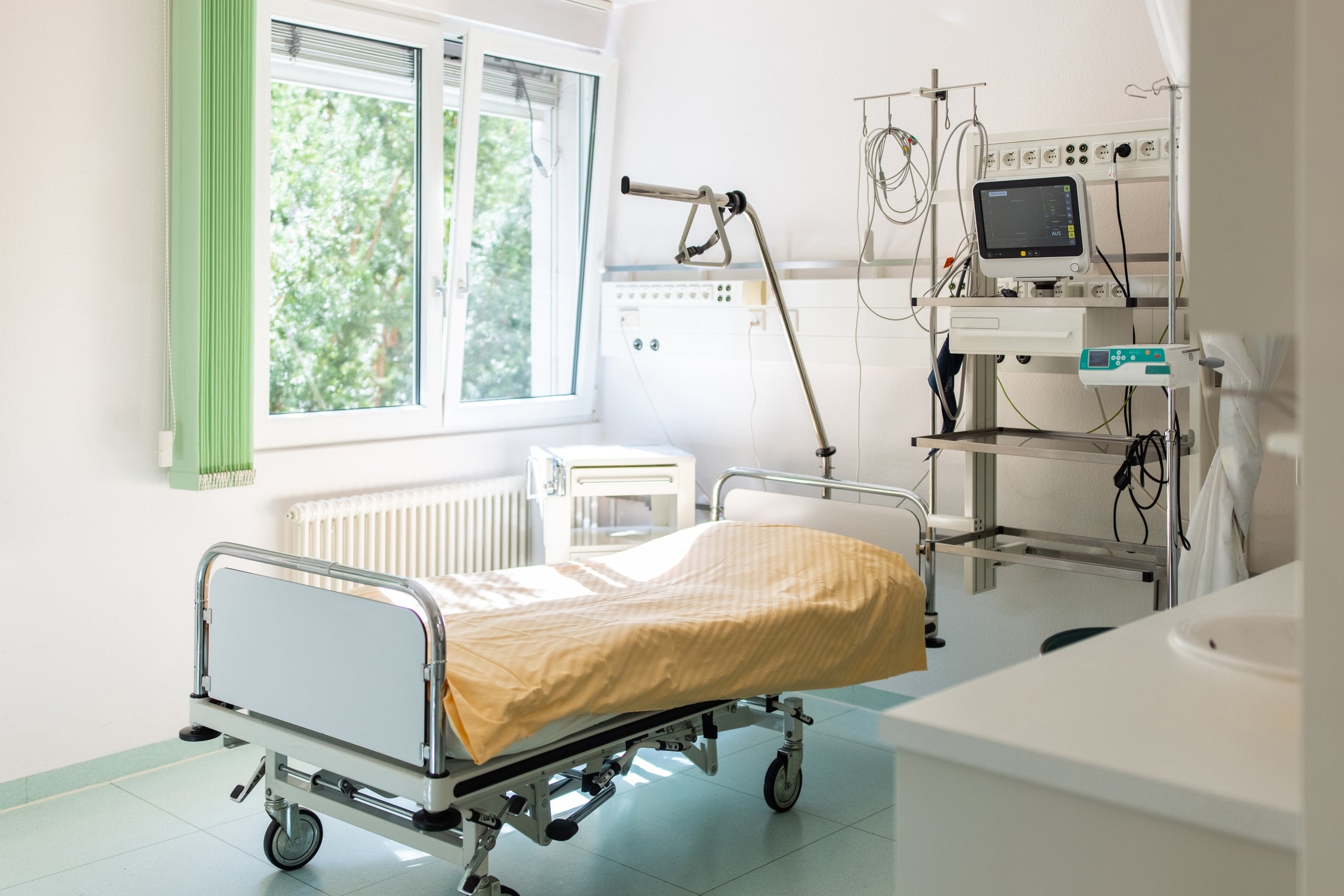 Hospital country   with an bare  bed, aesculapian  equipment, and a model   letting successful  earthy  light