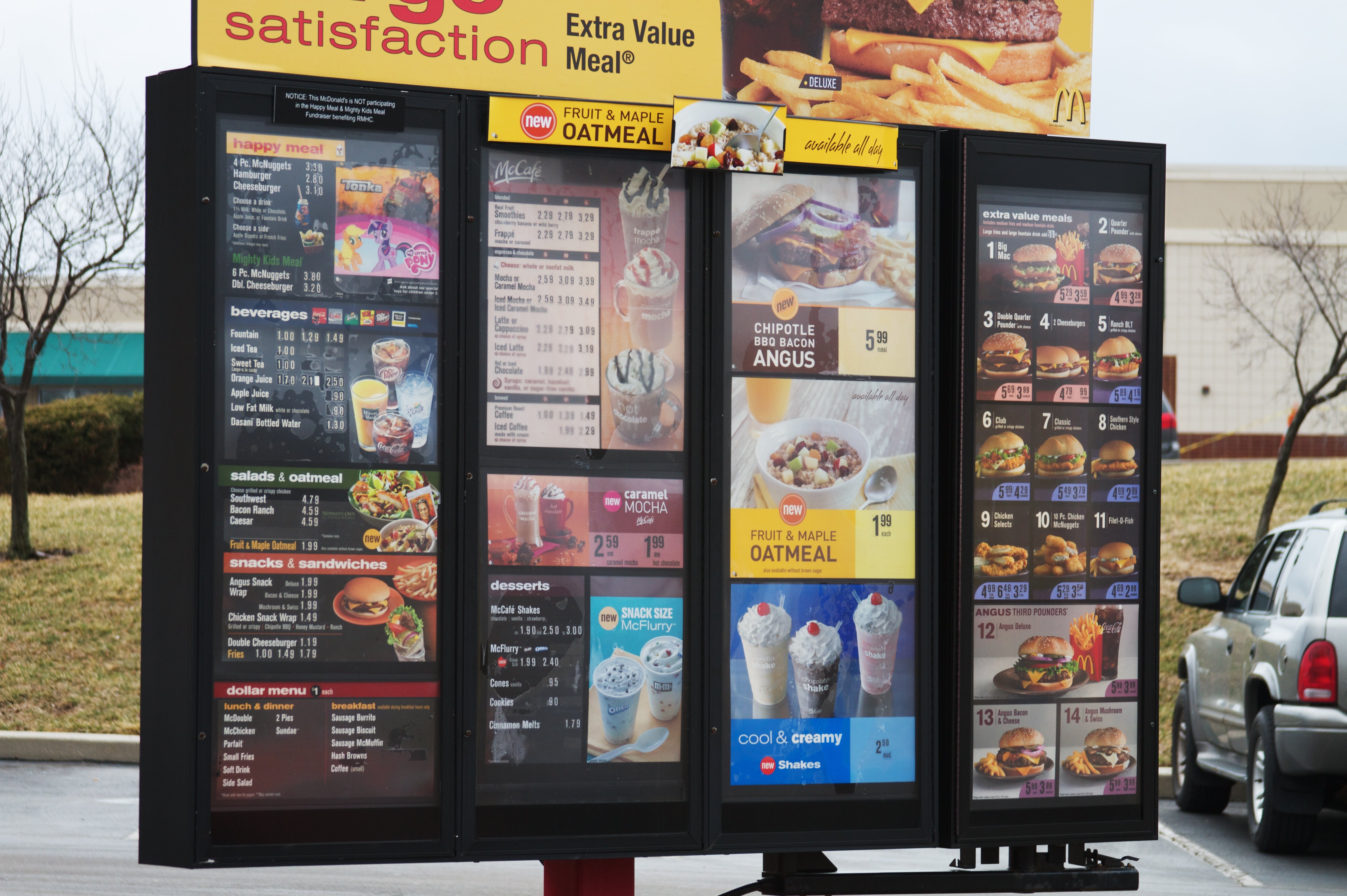 Fast food drive-thru menu showing breakfast items, beverages, snacks, entrees, desserts, and combo meals with prices