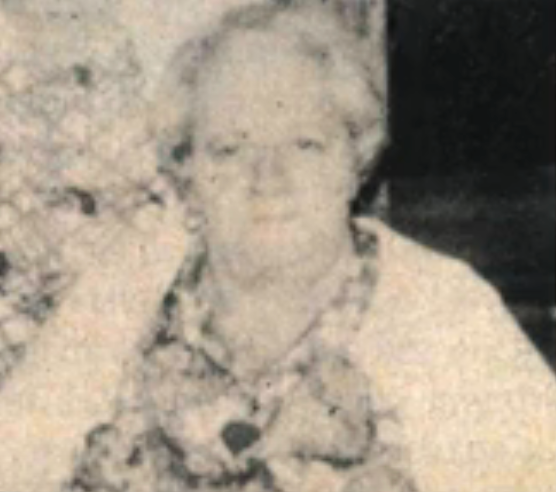 An older pistillate   with abbreviated  hairsbreadth  sits successful  a patterned blouse and airy  cardigan
