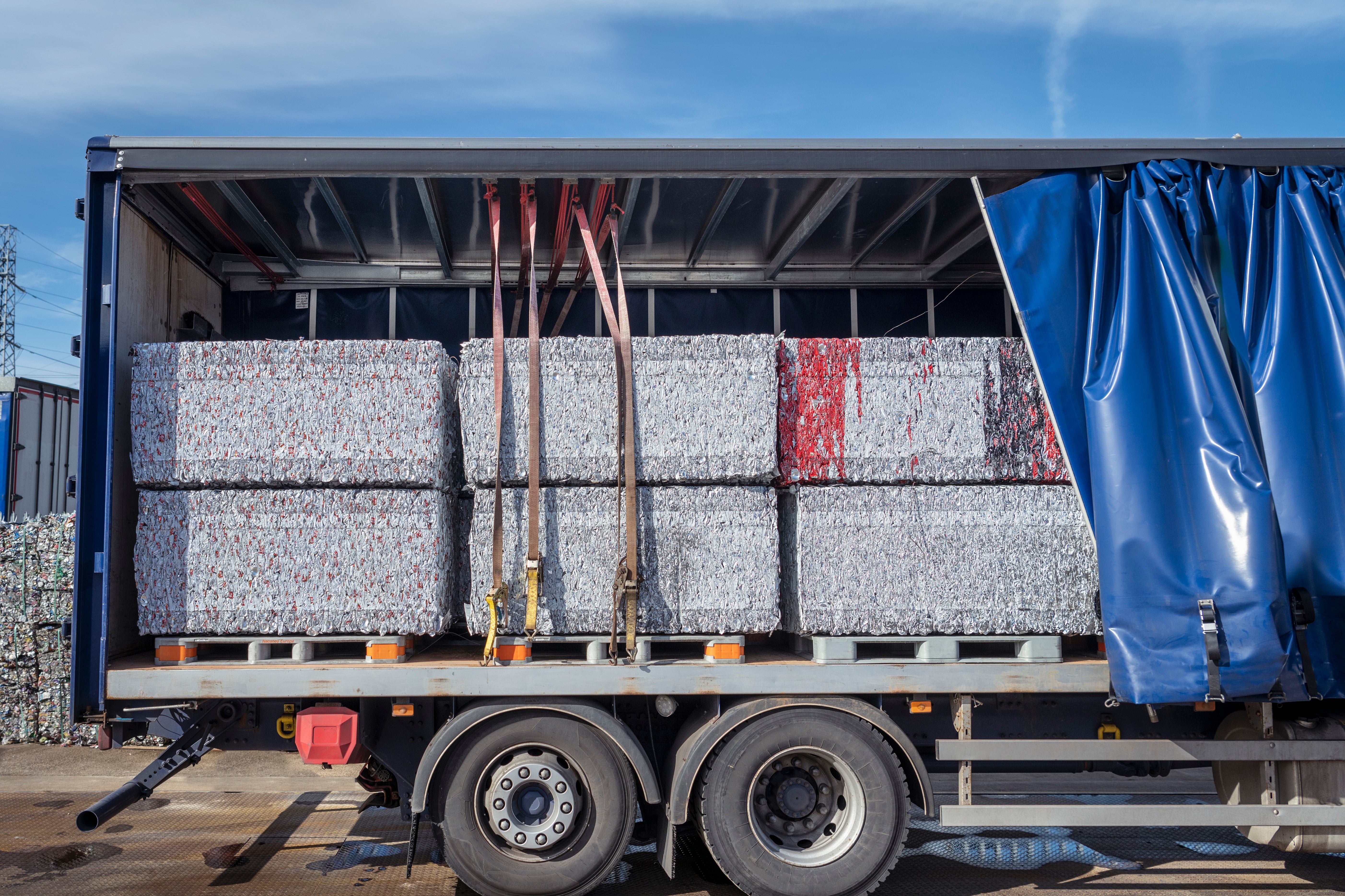 Open truck with large, compacted bales of scrap metal neatly stacked inside