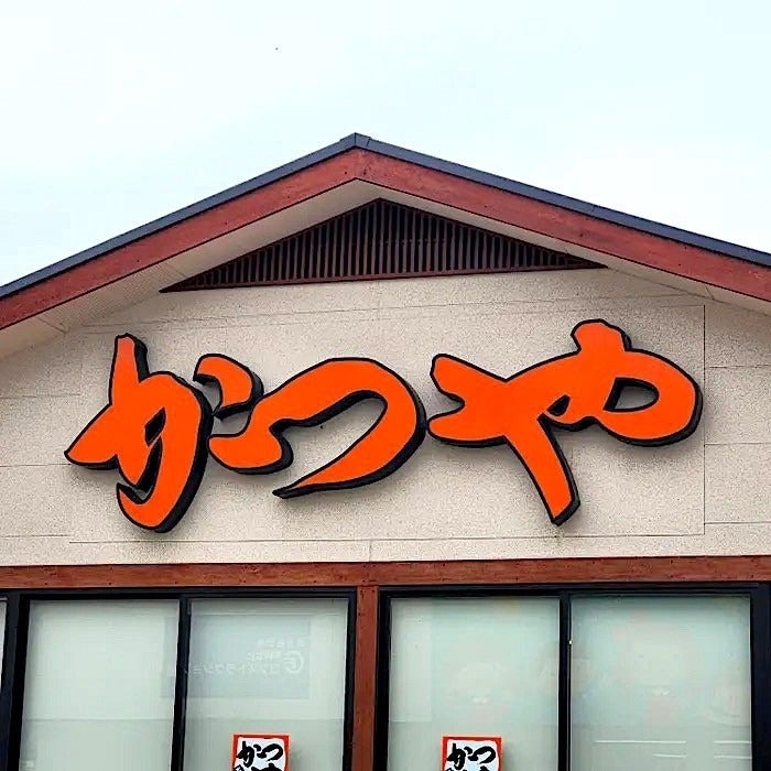 建物の上に「かつや」と書かれた大きな看板がある。