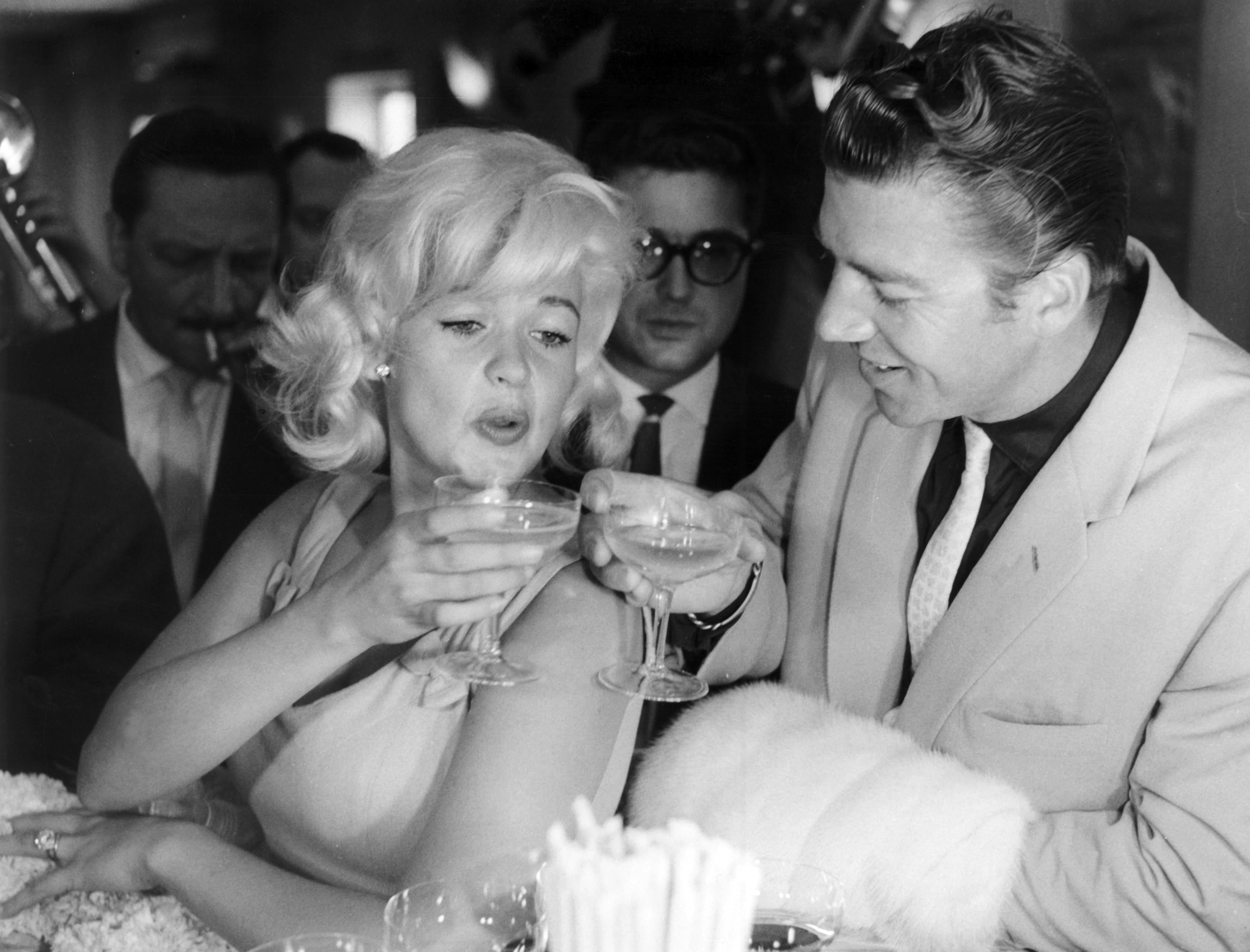 Jayne Mansfield with her husband Mike Hargitay clinking glasses together