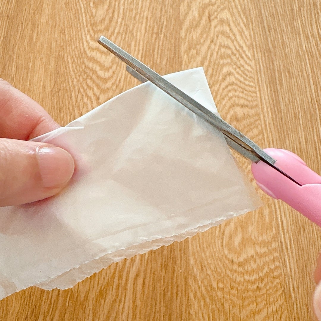 エアー緩衝材で作ったゴミ袋の一枚をハサミで切っている様子。