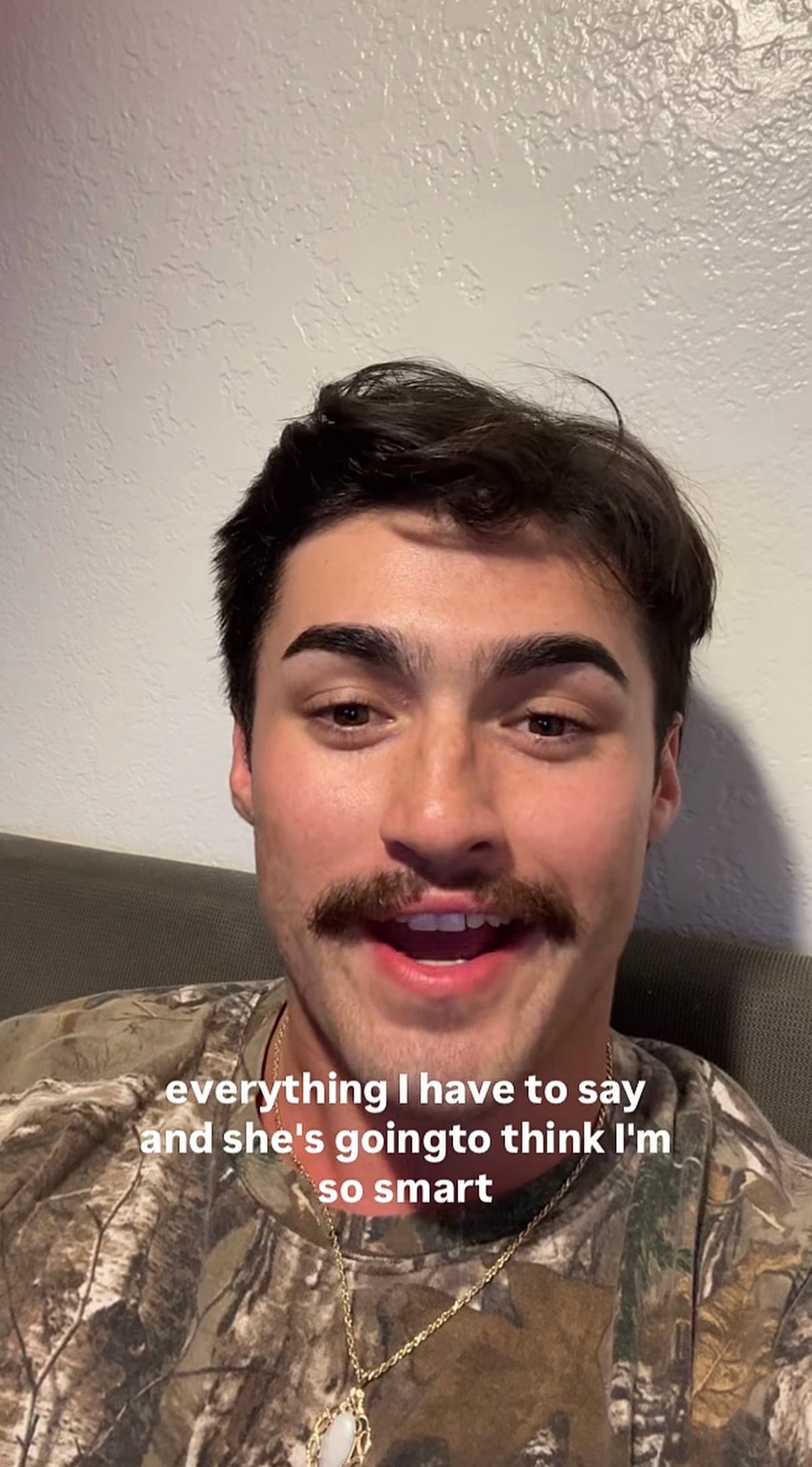 Man with a mustache speaking, wearing a camo shirt and gold necklace. Text on image implies he's impressing someone with his thoughts