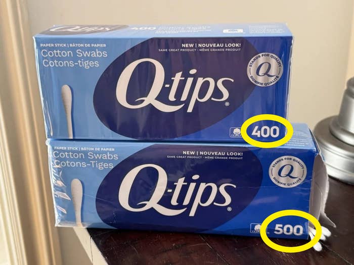 Two boxes of Q-tips fabric  swabs are stacked connected  a table, labeled with quantities of 400 and 500 each