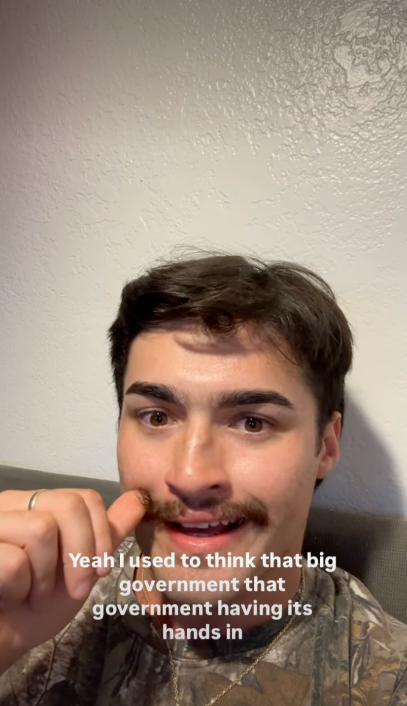Person with short hair and mustache smiling at camera. Text on image reads: "Yeah I used to think that big government that government having its hands in."