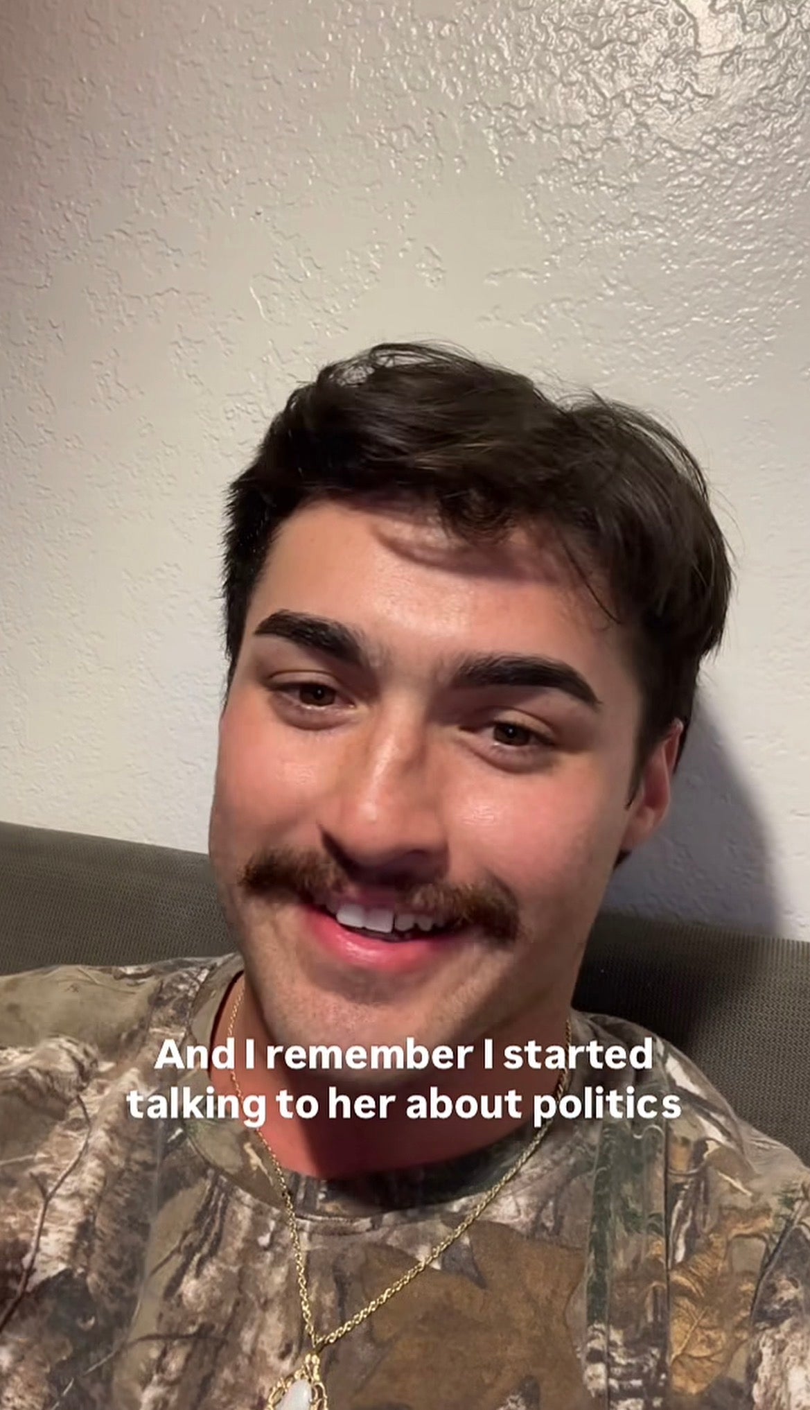 A person with a mustache in a camo-patterned shirt smiles at the camera. Text on the image reads: "And I remember I started talking to her about politics."