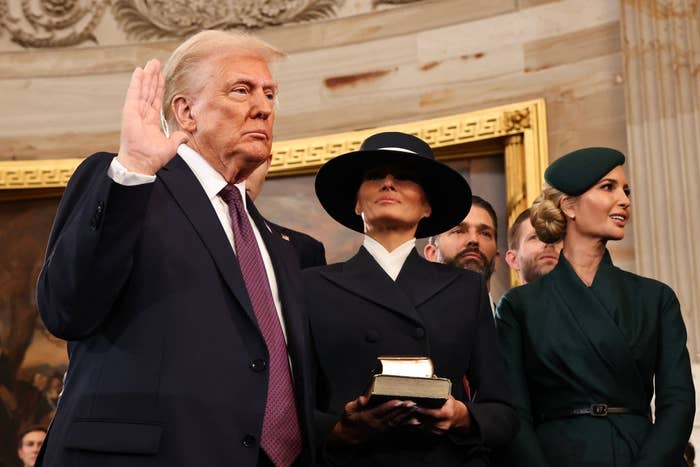I don't know who these individuals are, but the image shows a group of well-dressed people, with one person raising their hand for what appears to be a formal event