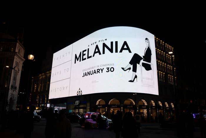 Billboard featuring a movie ad for "Melania," showing a stylishly dressed person with text "A new film, January 30, in cinemas."