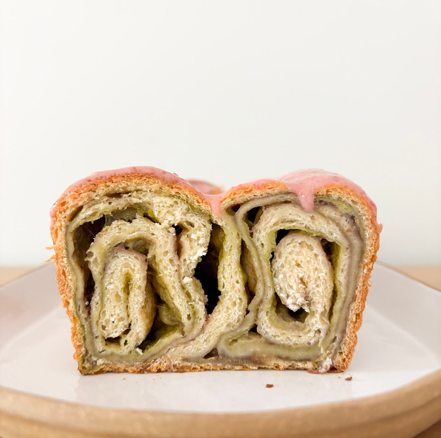 Swirled pastry slice on a plate, showcasing layers of dough and filling, likely sweet or savory