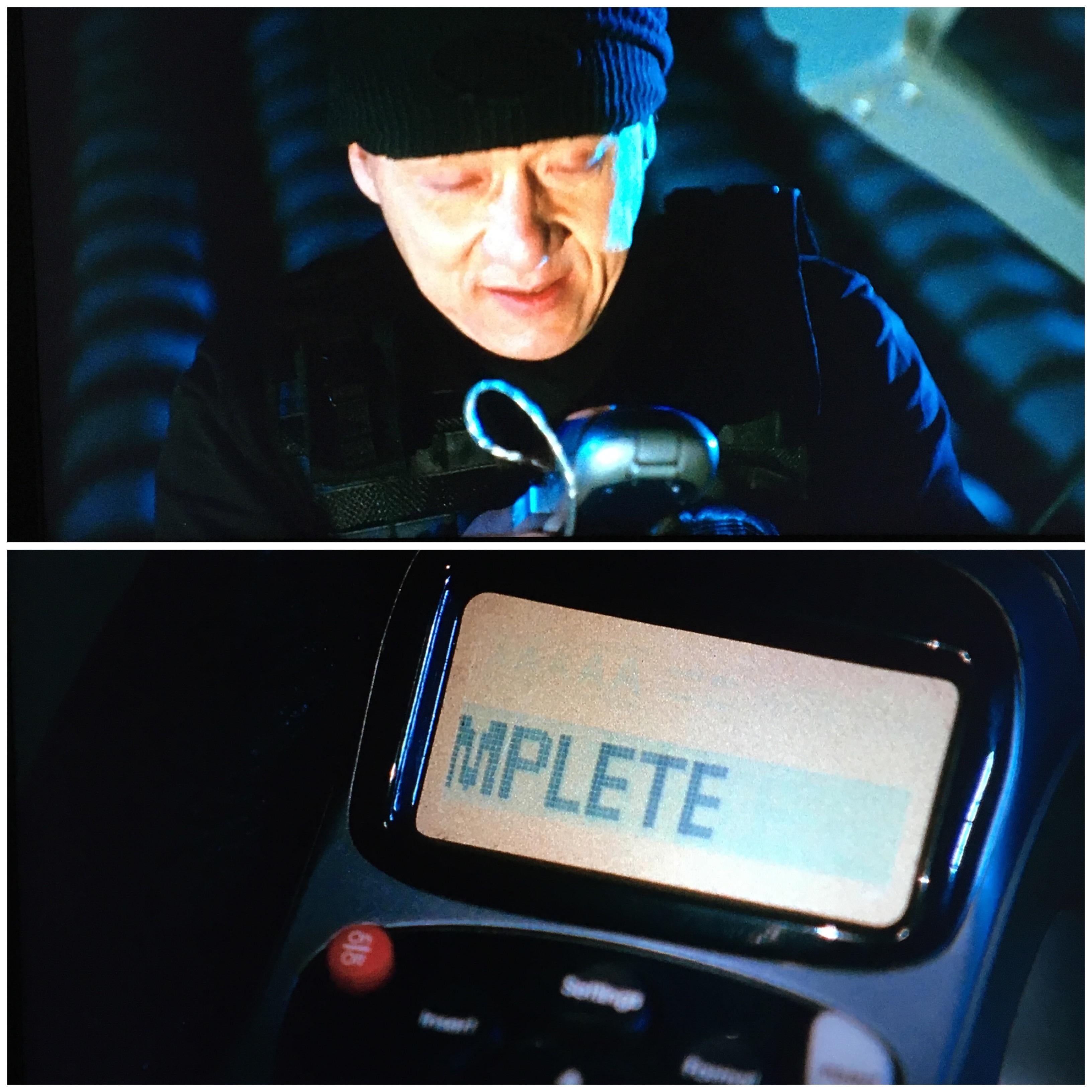 A person in a dark outfit holds a device. Below, a screen shows the word "MPLETE," implying a task is completed