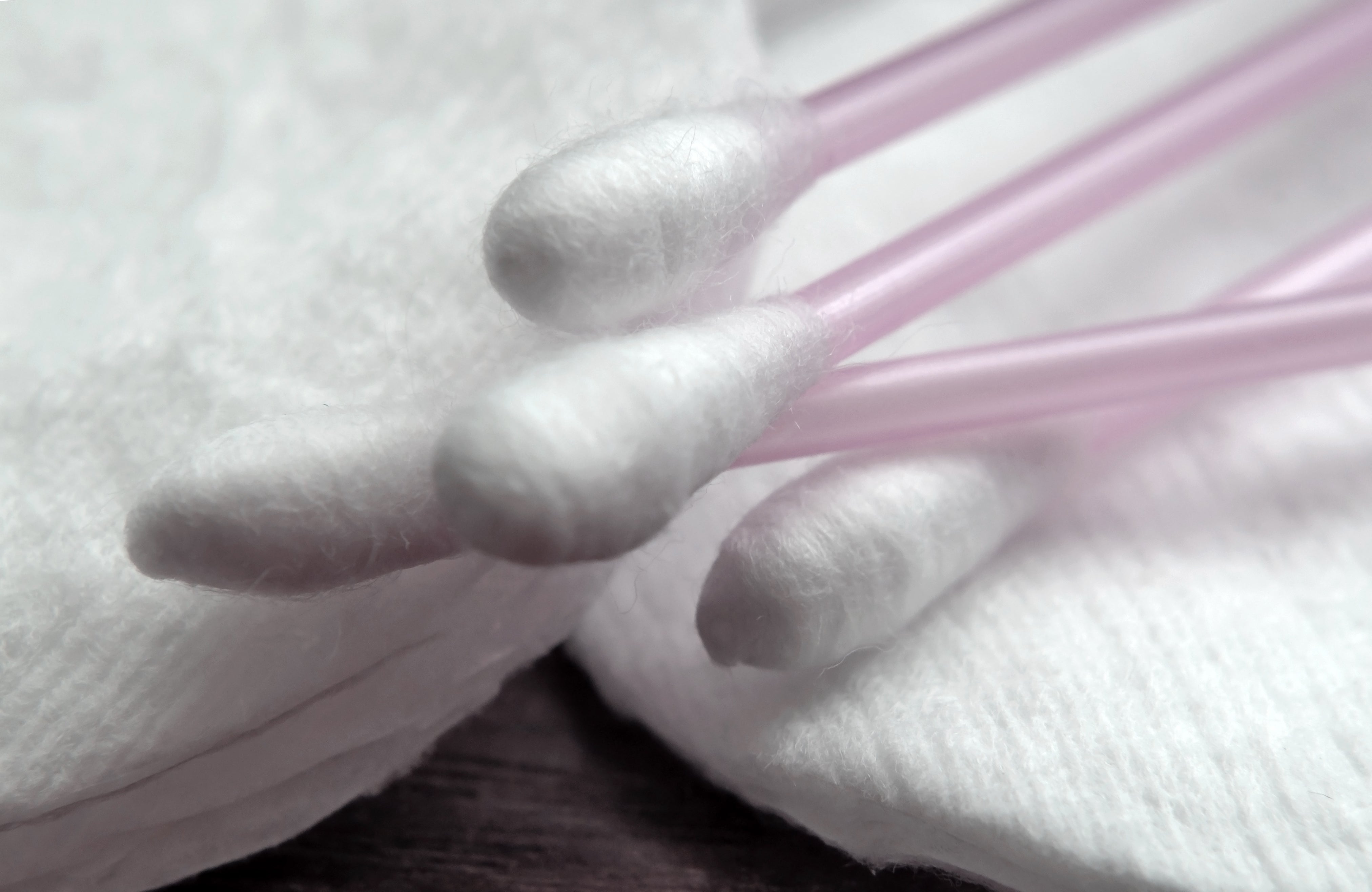 Cotton swabs resting on cotton pads, suggesting cleanliness and hygiene, possibly related to a personal care or work environment topic