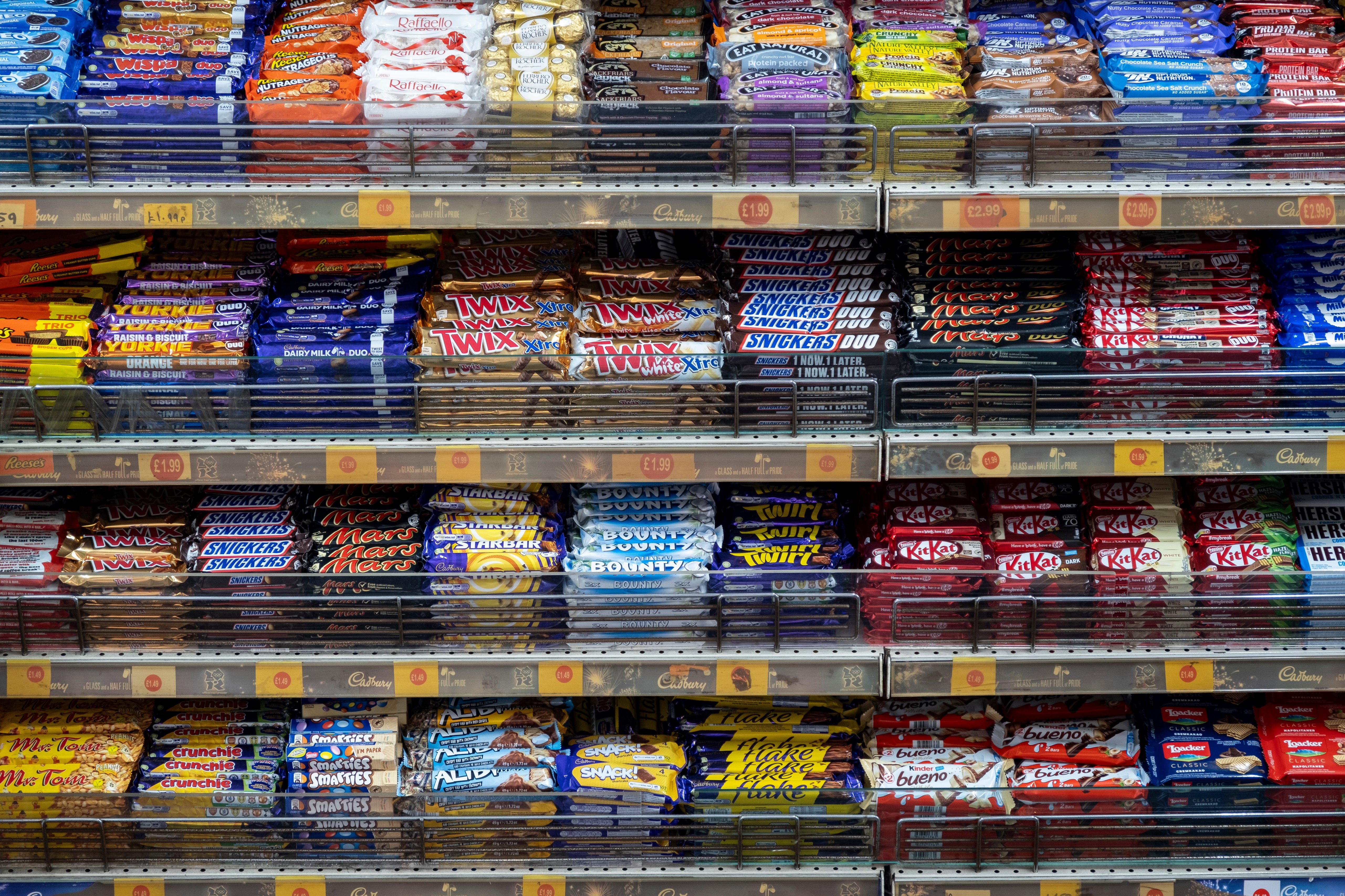 Shelves filled with various brands of chocolate bars in a store display
