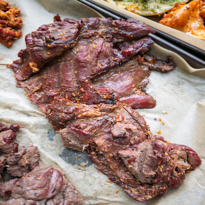 Cooked marinated beef on a baking tray, ready to be served