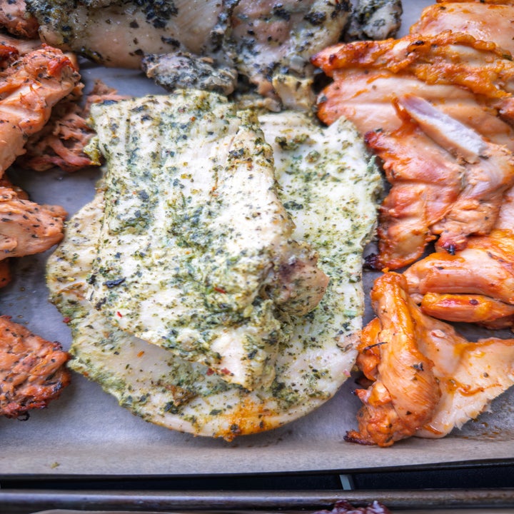 Various seasoned and cooked chicken pieces on a tray, showcasing different flavors and textures