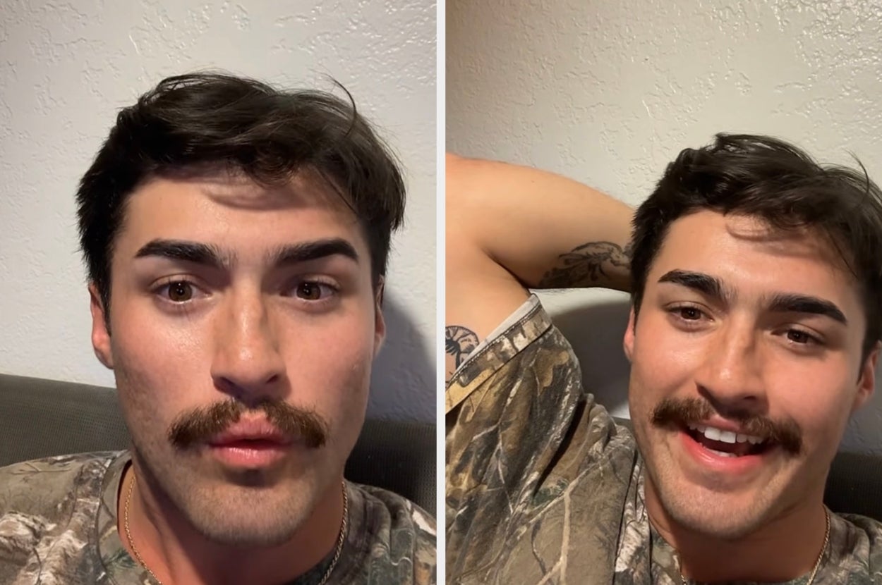 A person with a mustache is sitting on a couch in camo attire, first looking serious, then smiling