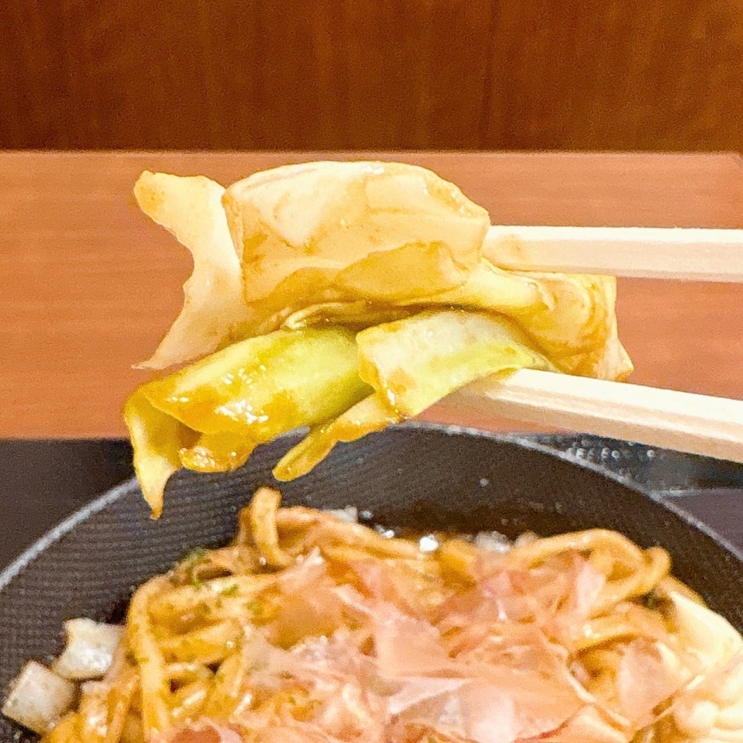 丸亀製麺「丸亀焼きうどん やみつきソース味」のキャベツを持ち上げている様子。