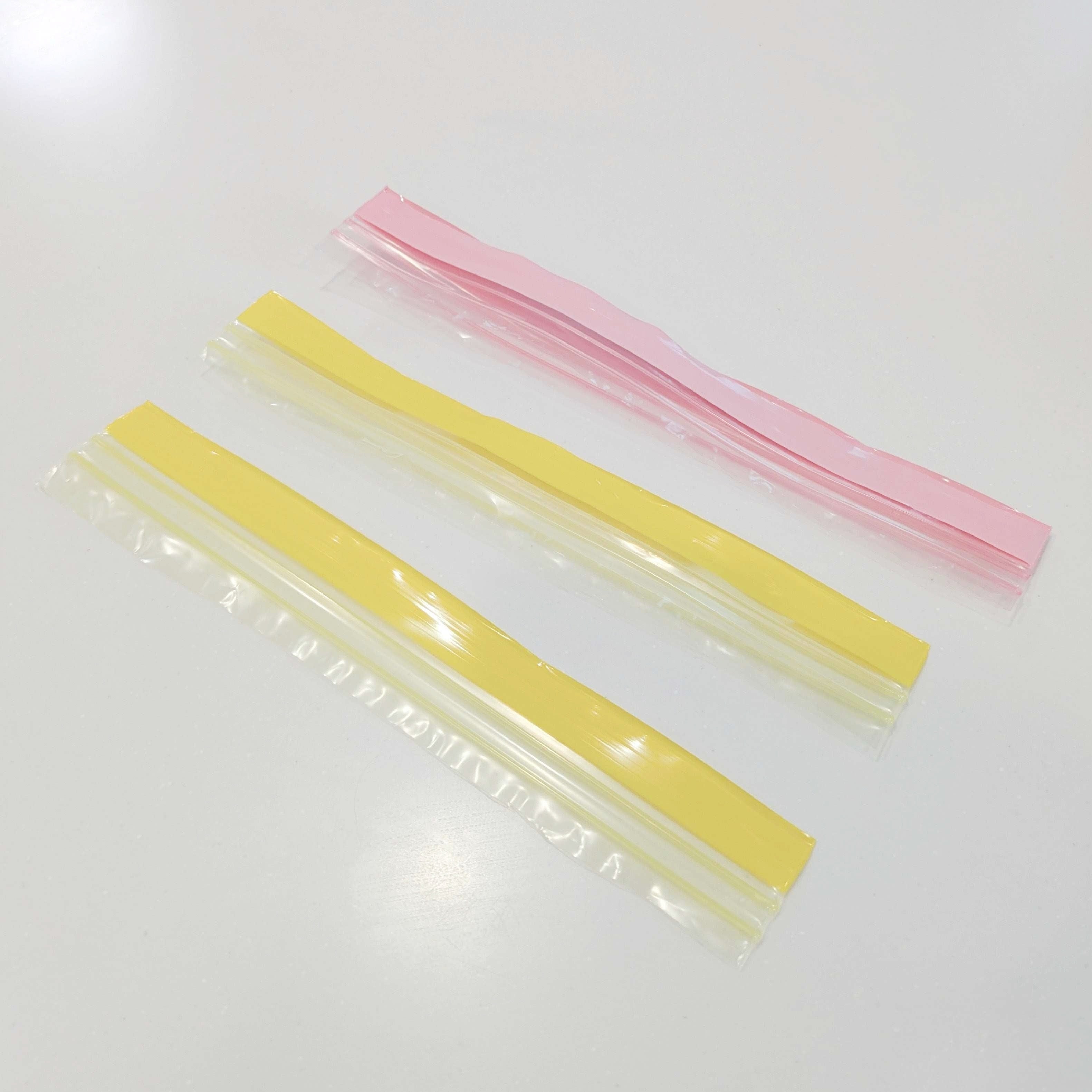 3本の色付きジッパー付き袋のジッパーが並んで置かれています。