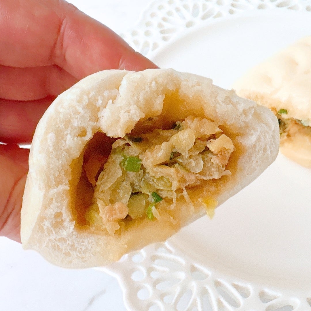 ミニストップの「餃子ドッグ」が半分に割られ、中の具材（肉や野菜）が見える。