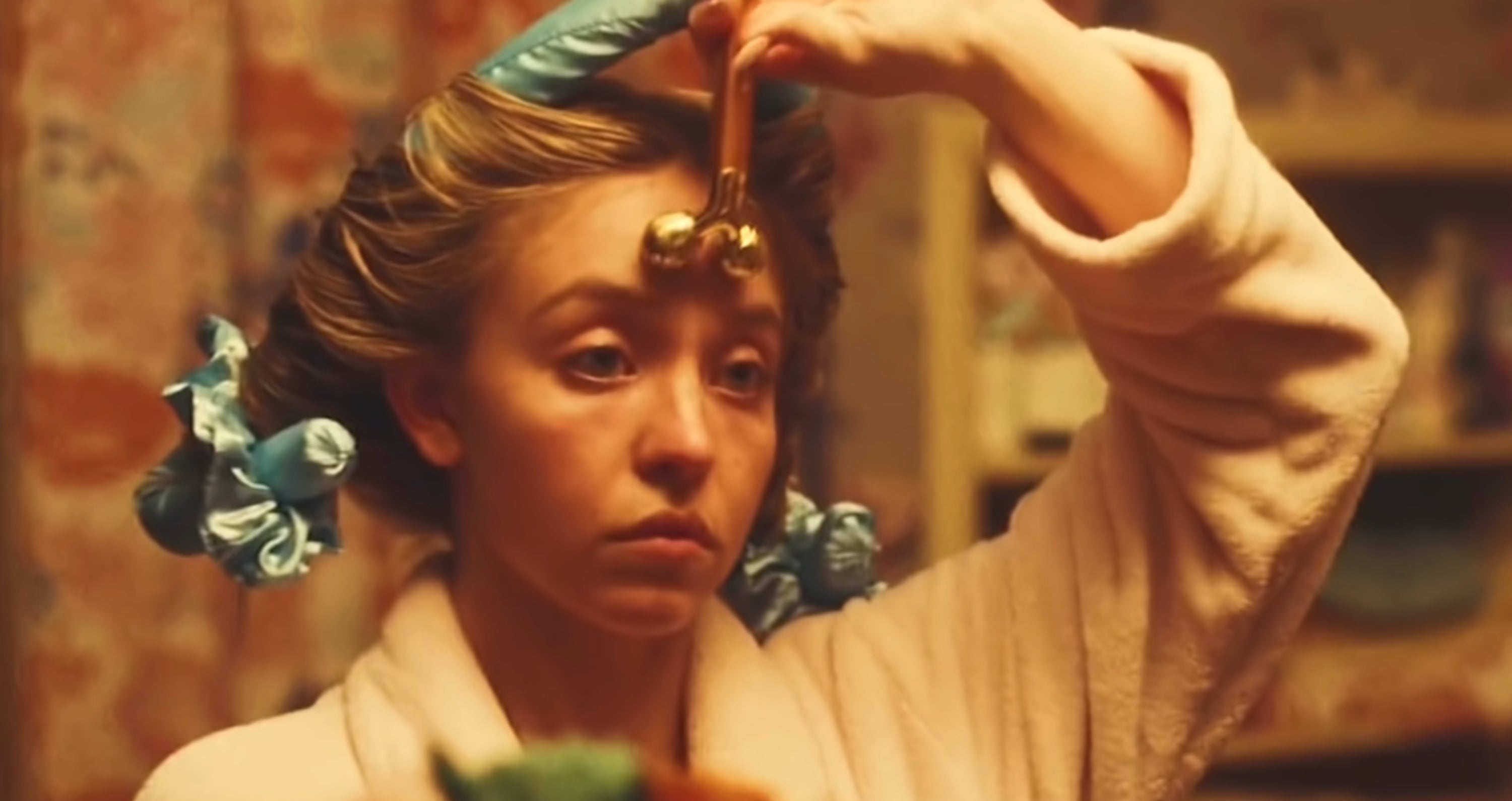 Sydney Sweeney getting ready in the bathroom, moving a roller over her face