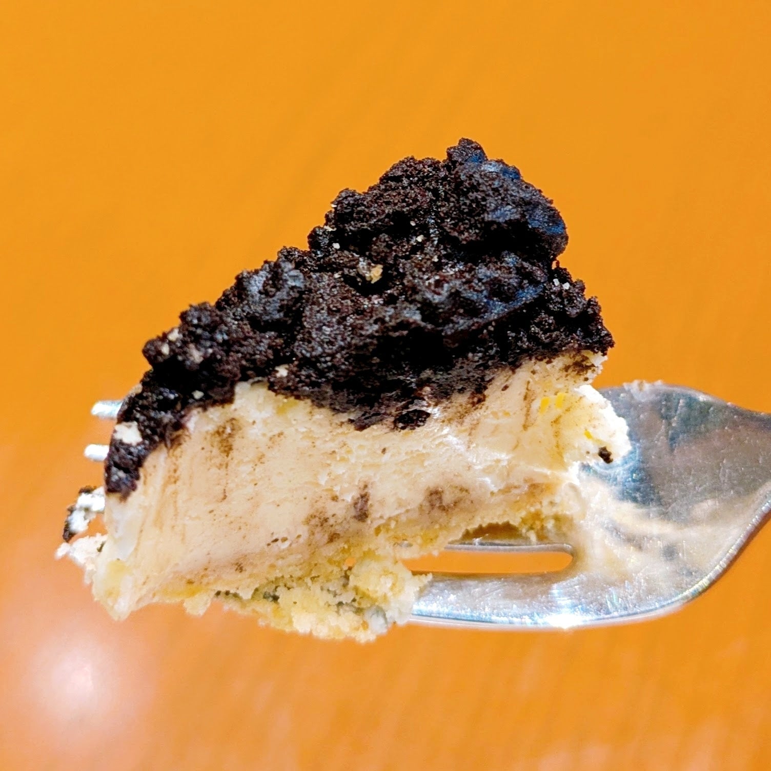 タリーズ「クッキークリームチーズケーキ」フォークに乗った一口サイズのクリームケーキ。上にはクッキーのようなトッピングがされています。
