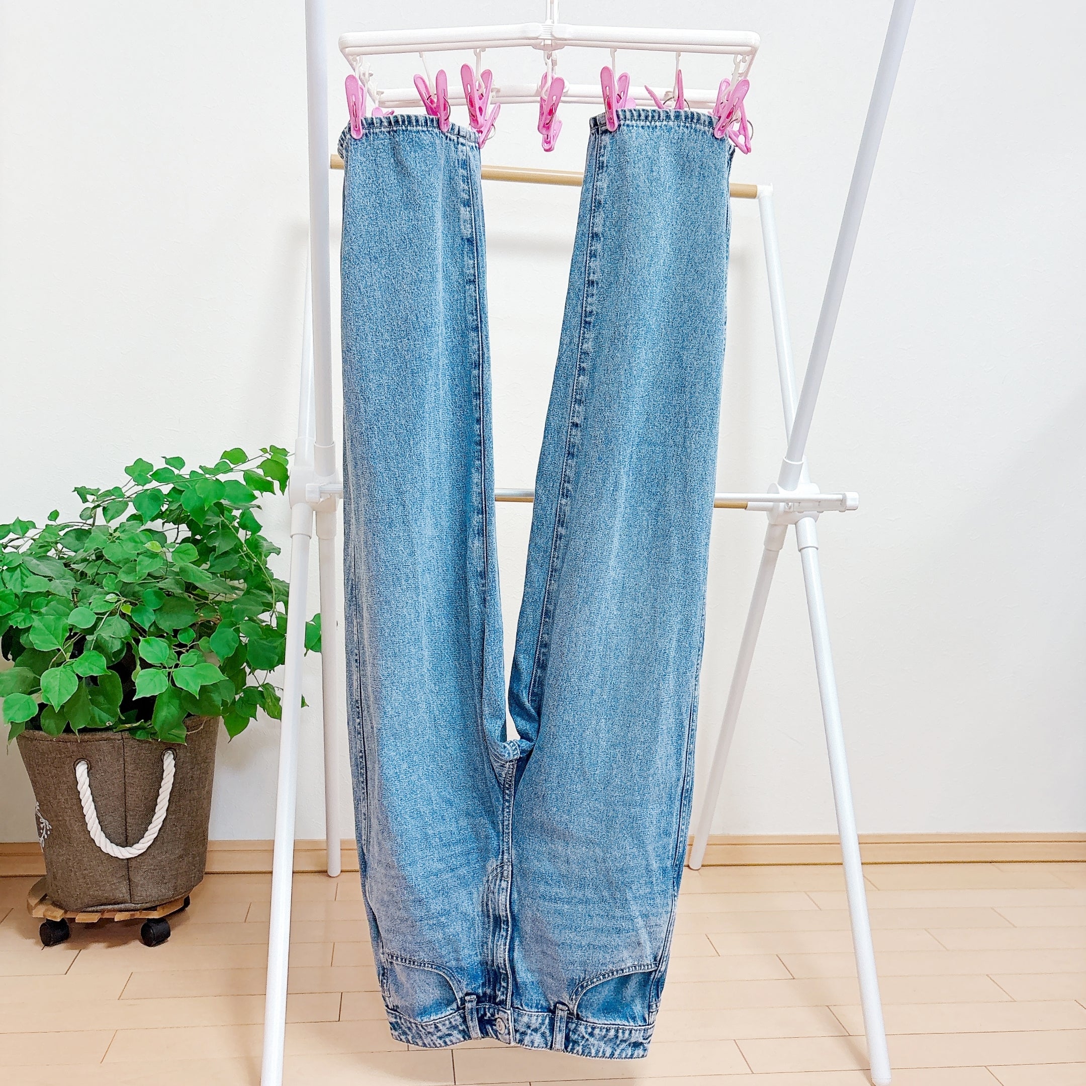 洗濯物ハンガーに逆さまに吊るされたデニムパンツ。