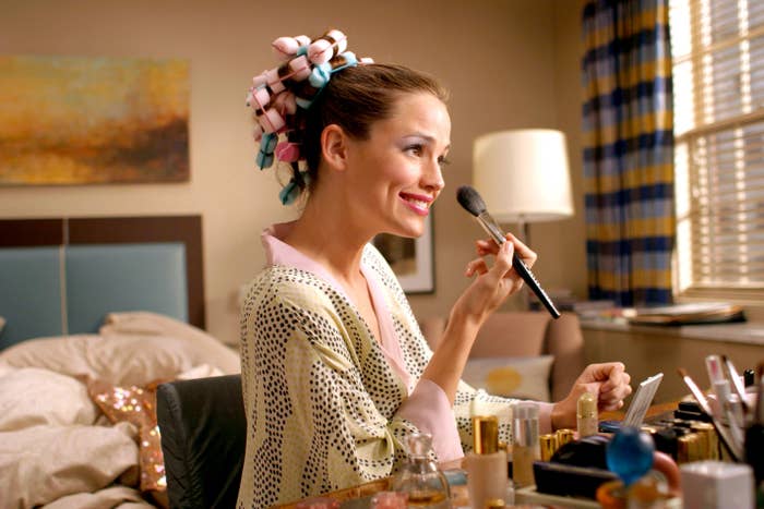 Jennifer Garner applying makeup, her hair is in rollers