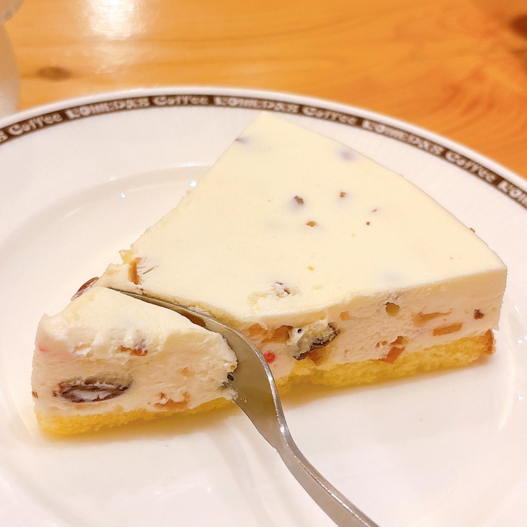コメダ珈琲店「くちどけカッサータ」プレートに乗ったチーズケーキの一切れをフォークで切っている様子。