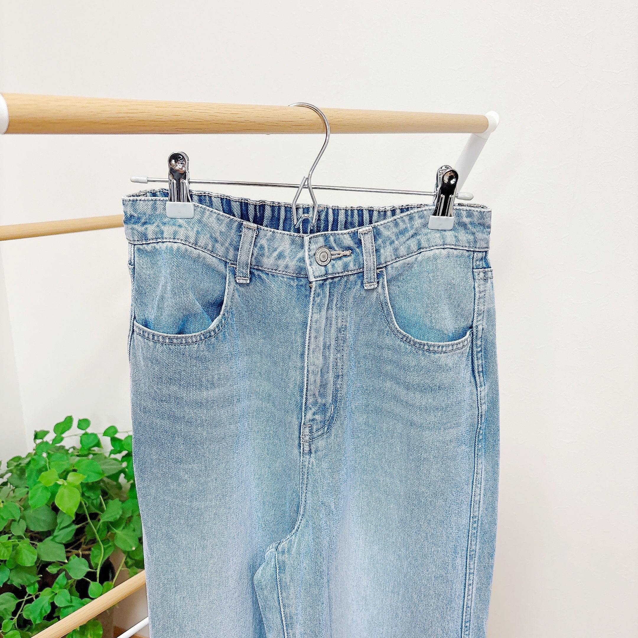 ハンガーにかけられたシンプルなデニムパンツ。