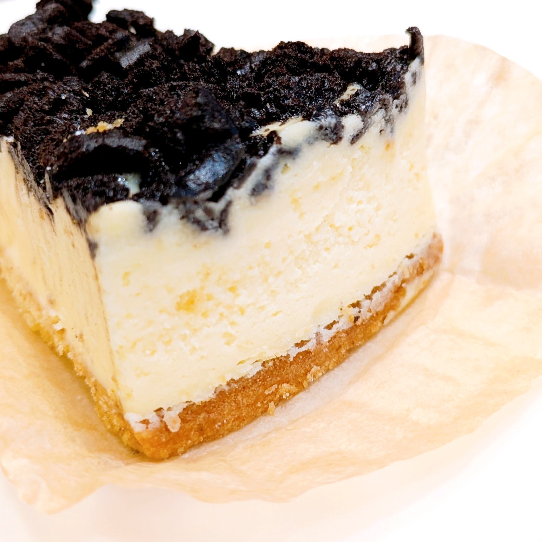 タリーズ「クッキークリームチーズケーキ」ケーキの断面。上に砕かれたクッキーがトッピングされています。