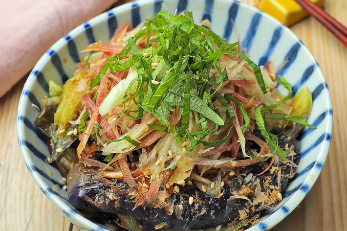 器に盛られた和風の茄子料理。薬味がたっぷり乗っていて、食欲をそそる見た目です。