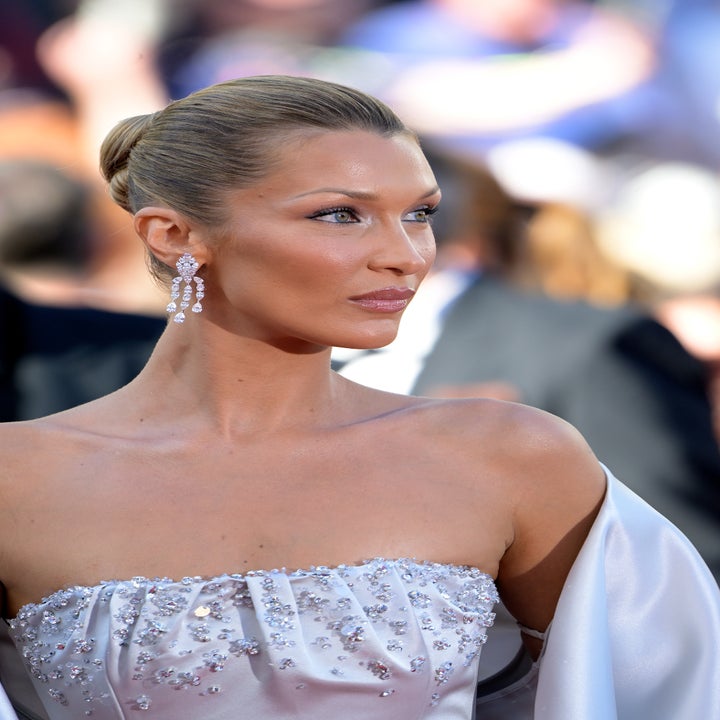 Person in elegant strapless gown adorned with sequins, wearing drop earrings, hair in a sleek updo, on what appears to be a formal event