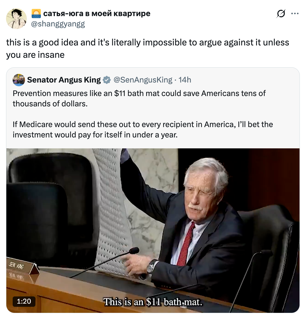 Man holds a large bath mat during a Senate session, captioned humorously as an "$11 bath mat."