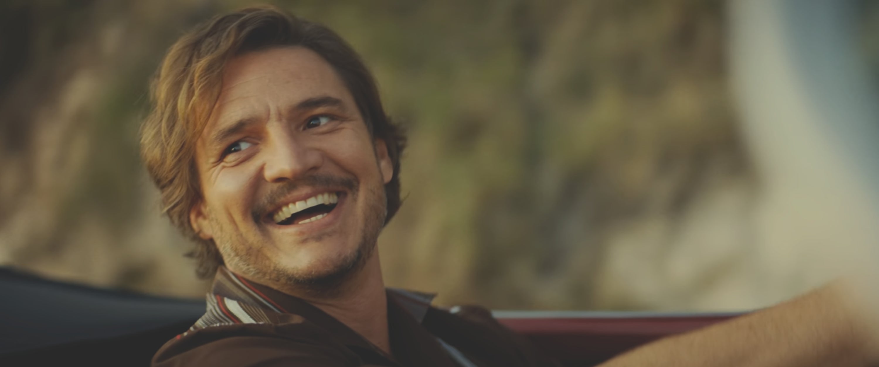 Person smiling and looking to the side while sitting in a car